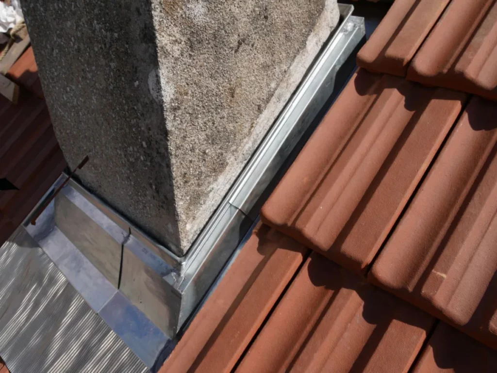 Abergement de cheminée en zinc assurant l’étanchéité de la toiture